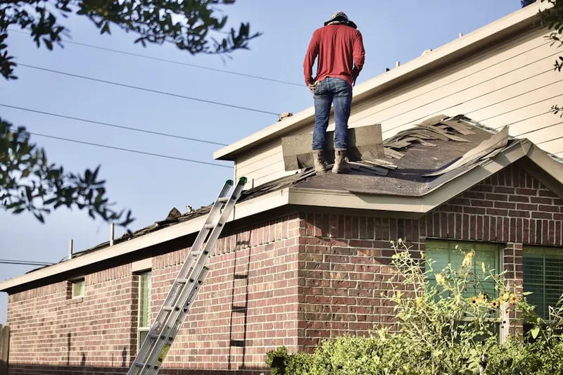 Professional roofer working on a residential roof in Fox Meadows